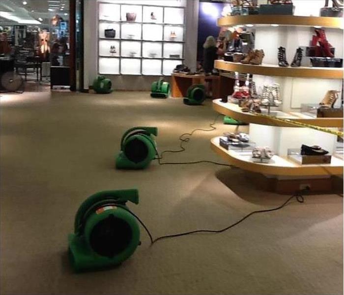 Air movers placed on carpet floor of a store